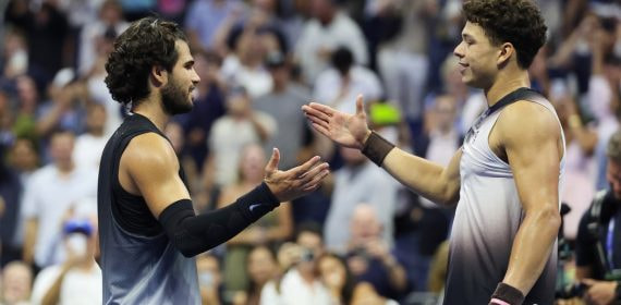 Carlos Alcaraz y Ben Shelton se saludan sobre la red al terminar su partido de cuartos de final del US Open