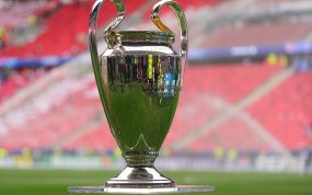 El trofeo de la Liga de Campeones sobre una peana de metacrilato en el césped de un estadio