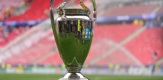 El trofeo de la Liga de Campeones sobre una peana de metacrilato en el césped de un estadio