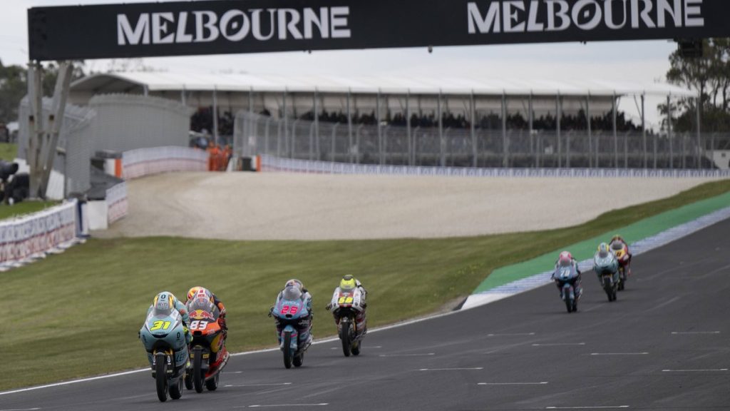Adrián Fernández, con el 31, y Álvaro Carpe, con el 83, encabezan un grupo de Moto3 en Phillip Island, bajo el pórtico de Melbourne