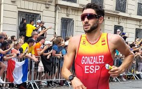 Alberto González corre con gafas de sol y el mono rojo de España ante el público que llena las vallas de una calle de París
