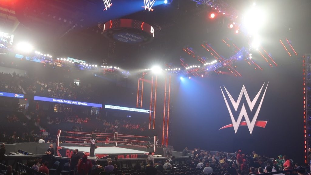 El ring de WWE montado en el Allstate Arena de Rosemont, con el logo de la compañía y el público llegando a las gradas