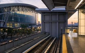 Andén vacío de una estación de metro moderna junto a un recinto ferial al anochecer