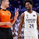 El árbitro Arnau Padrós, con camiseta naranja, hace un gesto con dos dedos junto a Andrés Feliz, del Real Madrid