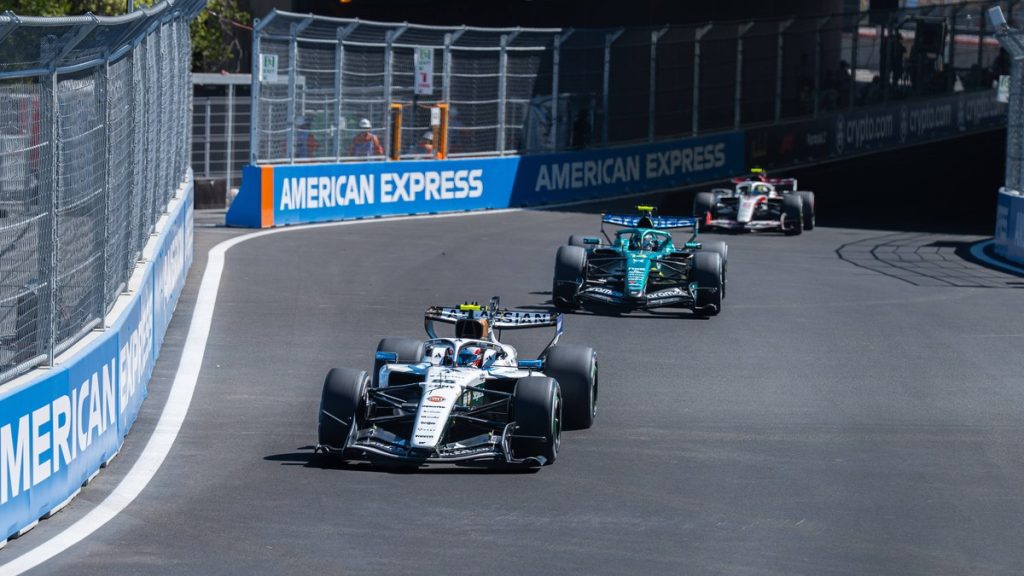 Un Williams blanco rueda por delante de un Aston Martin verde en una curva del circuito urbano del Madring, entre vallas