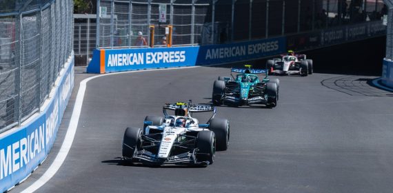 Un Williams blanco rueda por delante de un Aston Martin verde en una curva del circuito urbano del Madring, entre vallas