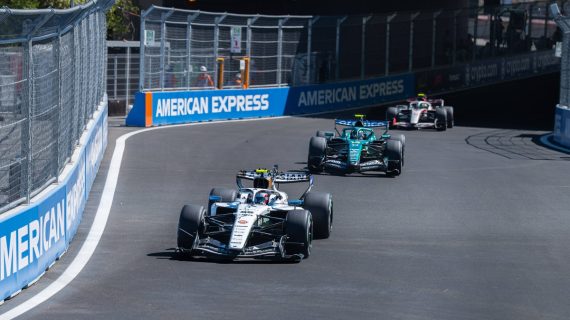 Un Williams blanco rueda por delante de un Aston Martin verde en una curva del circuito urbano del Madring, entre vallas