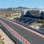 Recta de un circuito urbano de Fórmula 1 junto a un recinto ferial, con gradas vacías