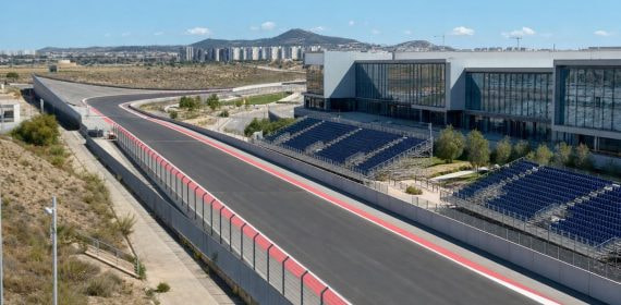 Recta de un circuito urbano de Fórmula 1 junto a un recinto ferial, con gradas vacías