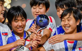 Jugadoras de Corea del Norte sonríen mientras sostienen el trofeo de campeonas del Mundial femenino sub-17