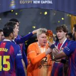 Emil Nielsen, con la camiseta naranja de portero, recibe el trofeo de campeón de manos de un compañero del Barça entre confeti dorado