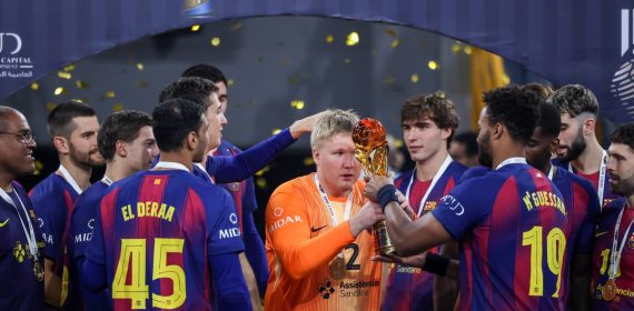 Emil Nielsen, con la camiseta naranja de portero, recibe el trofeo de campeón de manos de un compañero del Barça entre confeti dorado