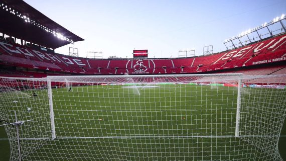 Vista del Estadio Ramón Sánchez-Pizjuán vacío desde detrás de la portería del Gol Sur, con las gradas rojas y el escudo del Sevilla al fondo