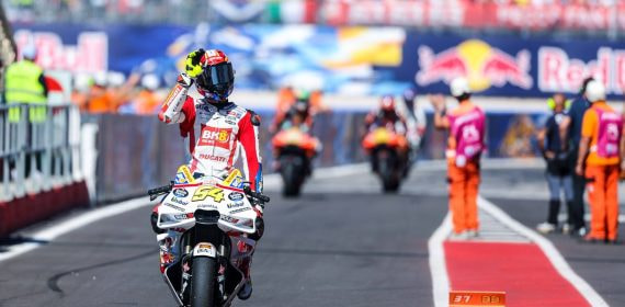Fermín Aldeguer saluda a un aficionado en el parque cerrado del Gran Premio de San Marino de MotoGP