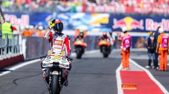 Fermín Aldeguer saluda a un aficionado en el parque cerrado del Gran Premio de San Marino de MotoGP