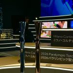 Las antorchas olímpica y paralímpica de Milano-Cortina 2026, sobre una peana iluminada junto a los rótulos del evento