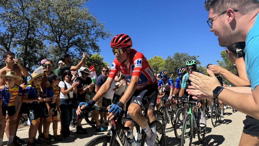 Enric Mas asciende con el maillot rojo de líder entre el público durante La Vuelta a España 2026