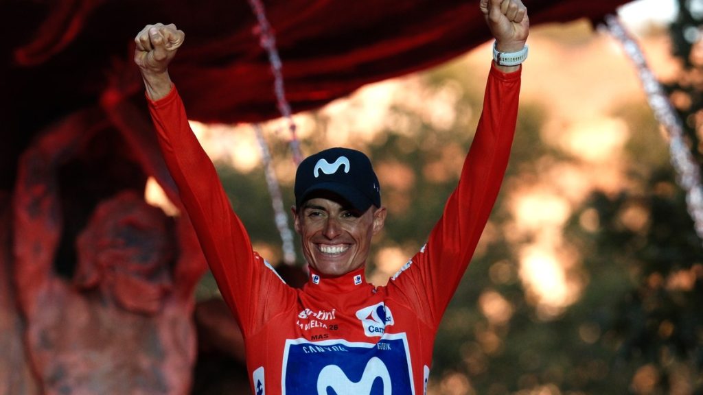 Enric Mas levanta los dos puños con el maillot rojo en el podio de Granada