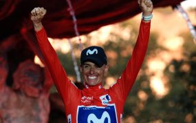 Enric Mas levanta los dos puños con el maillot rojo en el podio de Granada