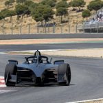 Un monoplaza eléctrico traza una curva en un circuito permanente rodeado de monte bajo