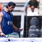 Juan Lebrón, con gorra y camiseta azul, aprieta el puño con la pala en la mano junto a la red de una pista de pádel