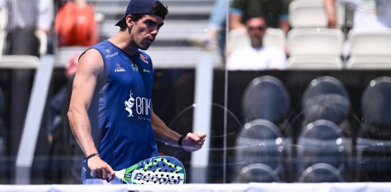 Juan Lebrón, con gorra y camiseta azul, aprieta el puño con la pala en la mano junto a la red de una pista de pádel