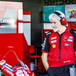 Gigi Dall'Igna, con cascos de radio, observa una Ducati en el box del equipo oficial durante un Gran Premio de MotoGP