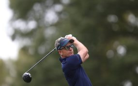 Luke Donald, con visera y gafas de sol, sigue la trayectoria de su golpe con el driver tras la salida en un tee arbolado