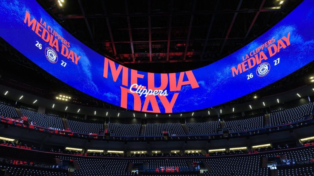 Pantalla gigante circular con el rótulo del media day de los Clippers sobre las gradas vacías de un pabellón