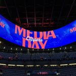 Pantalla gigante circular con el rótulo del media day de los Clippers sobre las gradas vacías de un pabellón