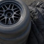 Neumáticos slick de competición apilados en el pit lane vacío de un circuito