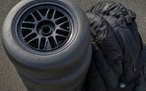 Neumáticos slick de competición apilados en el pit lane vacío de un circuito