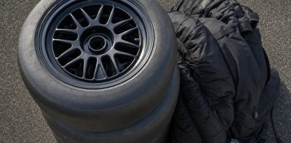 Neumáticos slick de competición apilados en el pit lane vacío de un circuito