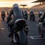 Motos de competición alineadas en la parrilla de salida de un circuito al atardecer