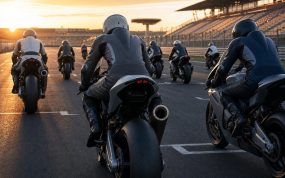 Motos de competición alineadas en la parrilla de salida de un circuito al atardecer