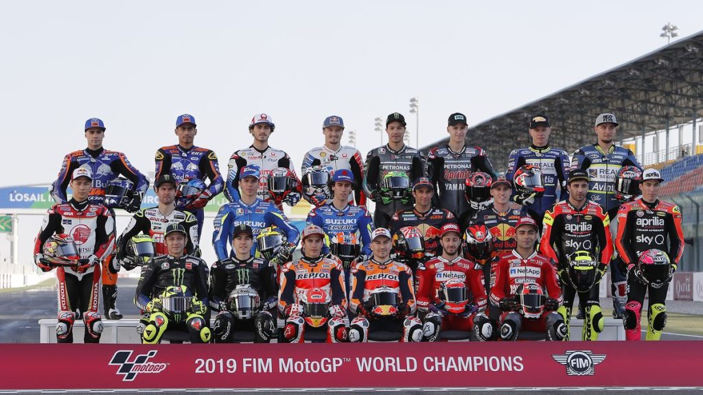Los pilotos del Mundial de MotoGP posan en la parrilla ante el cartel oficial del campeonato