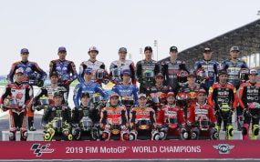 Los pilotos del Mundial de MotoGP posan en la parrilla ante el cartel oficial del campeonato