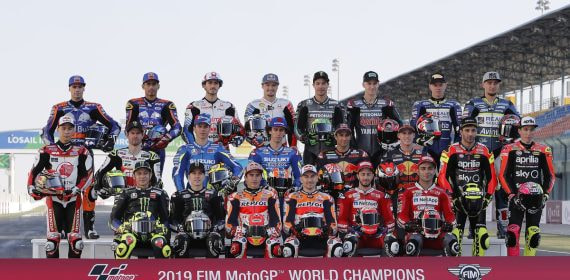 Los pilotos del Mundial de MotoGP posan en la parrilla ante el cartel oficial del campeonato