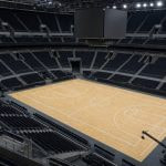 Pista de baloncesto vacía de un pabellón moderno vista desde la esquina alta del graderío