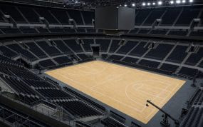 Pista de baloncesto vacía de un pabellón moderno vista desde la esquina alta del graderío