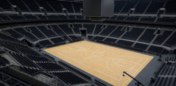 Pista de baloncesto vacía de un pabellón moderno vista desde la esquina alta del graderío
