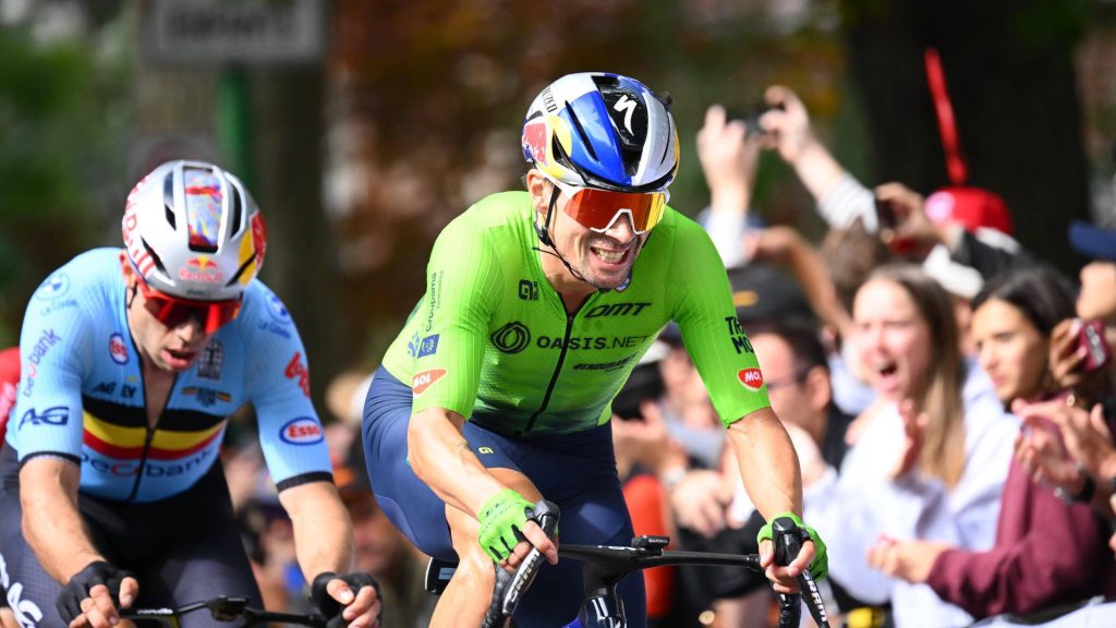 Primož Roglič, con el maillot verde de Eslovenia, pedalea por delante de Wout van Aert ante el público