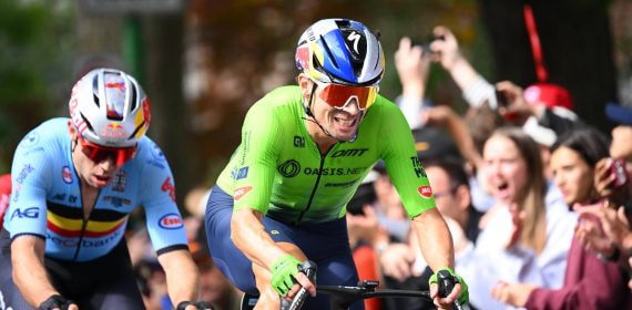 Primož Roglič, con el maillot verde de Eslovenia, pedalea por delante de Wout van Aert ante el público
