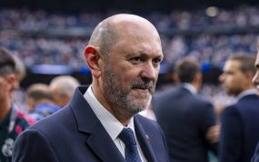Rafael Louzán, presidente de la RFEF, con traje azul marino sobre el césped de un estadio con las gradas llenas