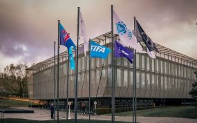 Fachada acristalada de la sede de la FIFA en Zúrich con las banderas de las confederaciones continentales