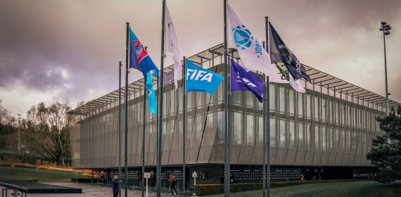 Fachada acristalada de la sede de la FIFA en Zúrich con las banderas de las confederaciones continentales