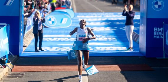 Tigst Assefa, con los brazos abiertos y la mirada al cielo, rompe la cinta de meta sobre la alfombra azul del maratón