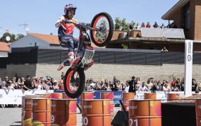 Toni Bou, con casco y mono de Repsol, salta con su moto de trial sobre una fila de barriles naranjas ante el público