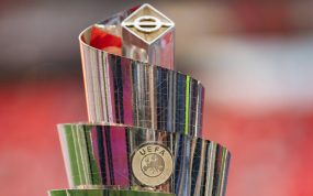 Trofeo plateado de la UEFA Nations League en forma de espiral, con el escudo de la UEFA y un fondo rojo desenfocado