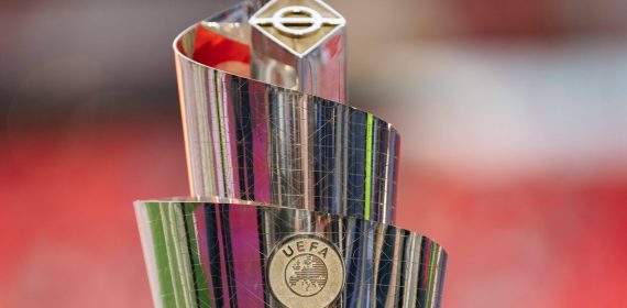 Trofeo plateado de la UEFA Nations League en forma de espiral, con el escudo de la UEFA y un fondo rojo desenfocado